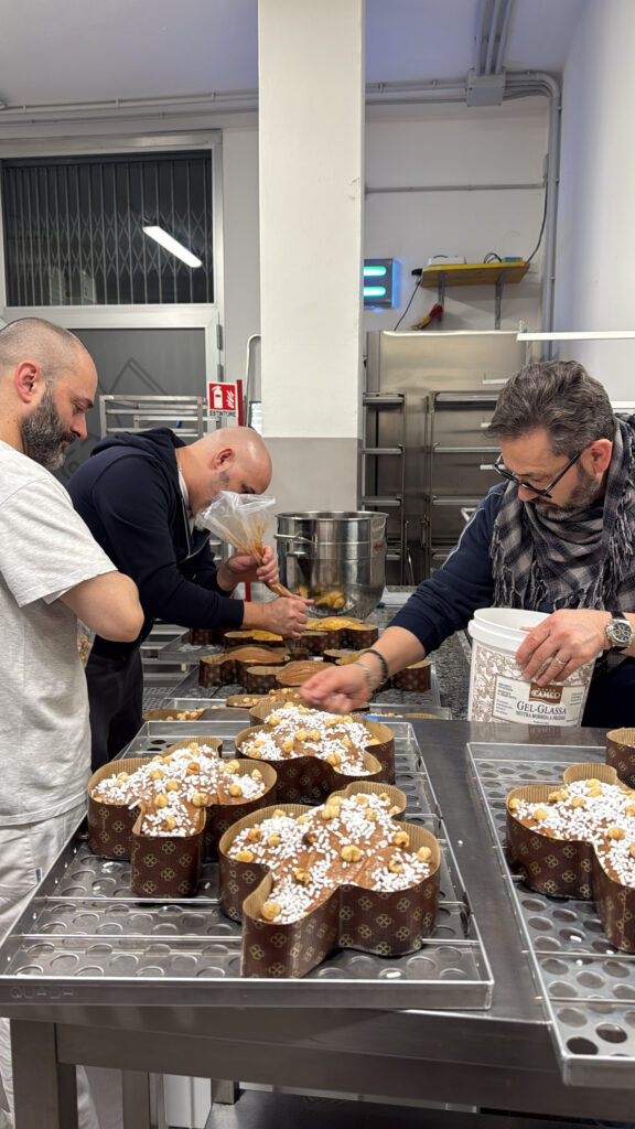 I nostri maestri pasticceri al lavoro sulla finitura manuale delle glasse.